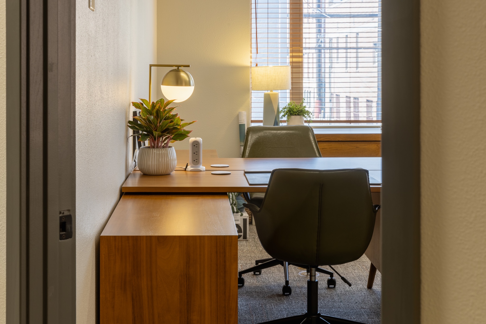 Private office suite with wood desk, leather chairs, and a downtown Wenatchee view